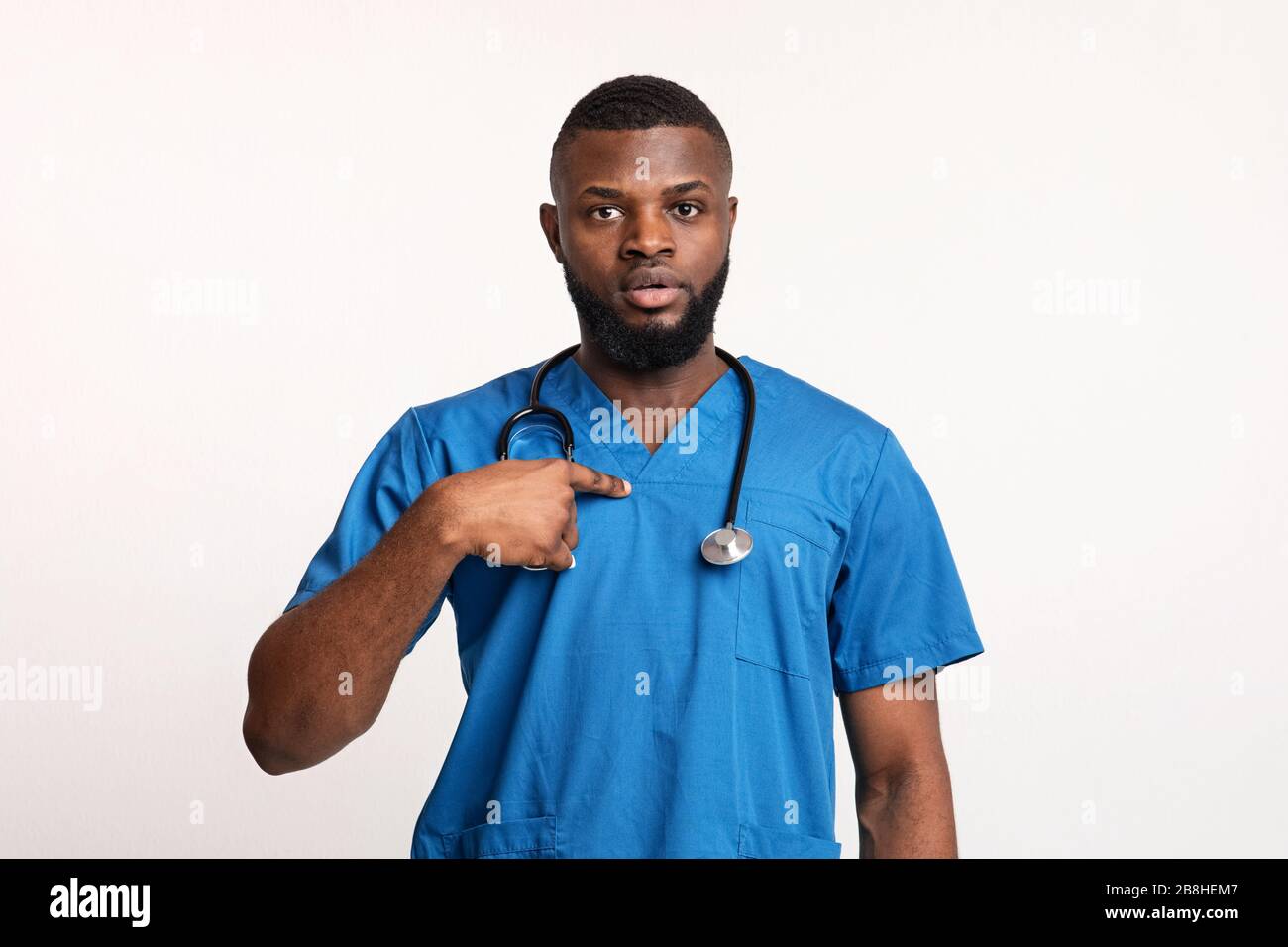 Sorpreso medico africano maschile che indica se stesso Foto Stock