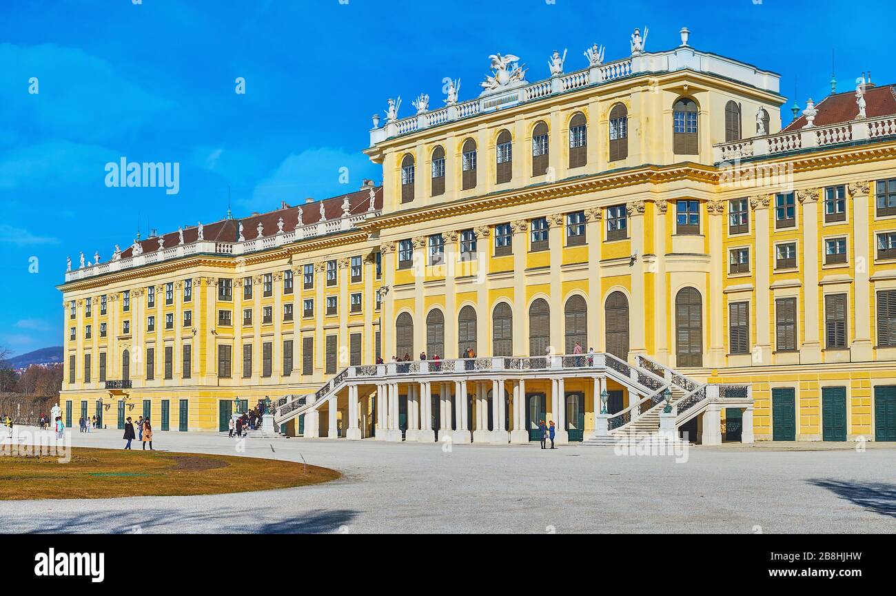 VIENNA, AUSTRIA - 19 FEBBRAIO 2019: La facciata gialla del palazzo Schonbrunn con colonne, finestre ad arco, scala curva, finestre ad arco e frontone Foto Stock