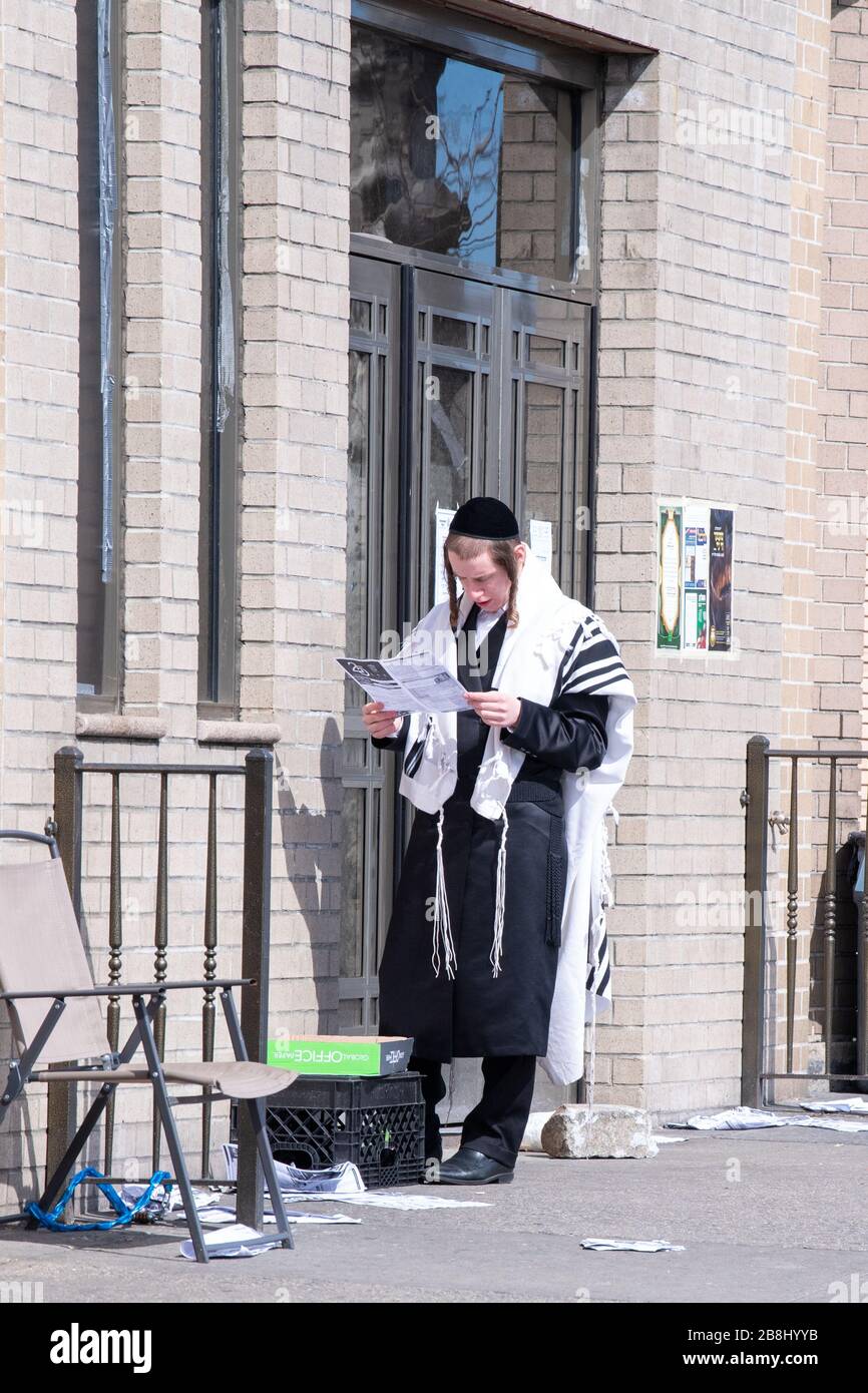 New York, Stati Uniti. 21 Mar 2020. Un ebreo di Satmar hasidic legge una nuova lettera fuori di una sinagoga chiuso per il servizio di preghiere di Sabbath dovuto la diffusione del coronavirus attraverso gli Stati Uniti.l'Organizzazione Mondiale della Sanità ha dichiarato il coronavirus (COVID-19) una pandemia globale il 11 marzo. Credit: SOPA Images Limited/Alamy Live News Foto Stock
