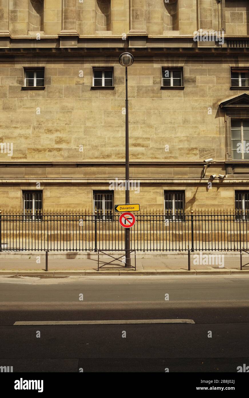 Un muro di pietra calcarea, un recinto stradale, un lampione, un cartello stradale di deviazione, telecamere di sorveglianza, Ministero degli Affari Esteri; Rue de l'Université; Parigi. Foto Stock