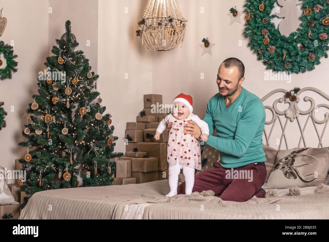 Buon giovane padre con il suo dolce bambino nella foto di natale Foto Stock