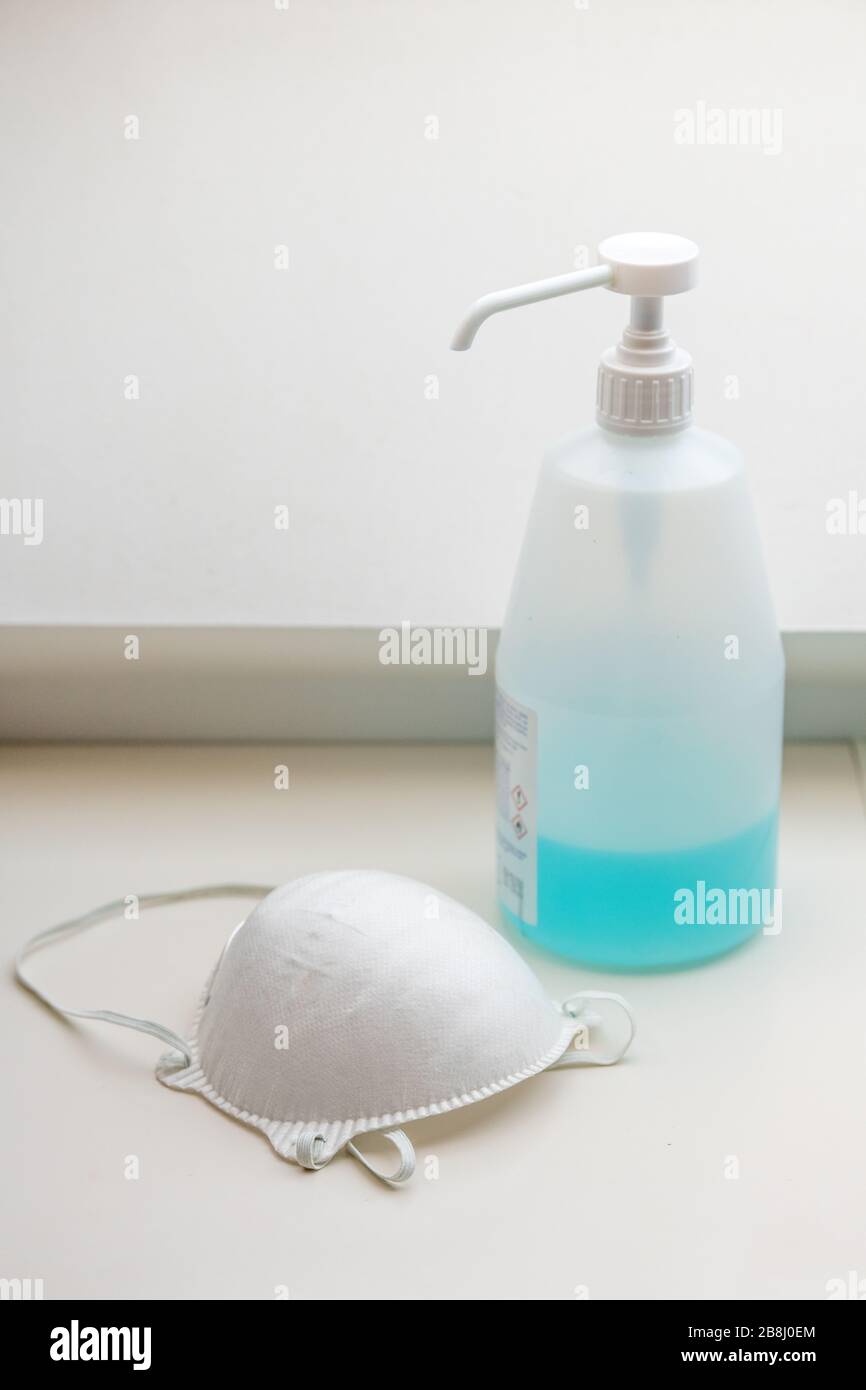 Maschera medica bianca un gel idroalcolico. Maschera facciale e gel idroalcolico, protezione contro l'inquinamento, virus, influenza e coronavirus. Assistenza sanitaria e. Foto Stock