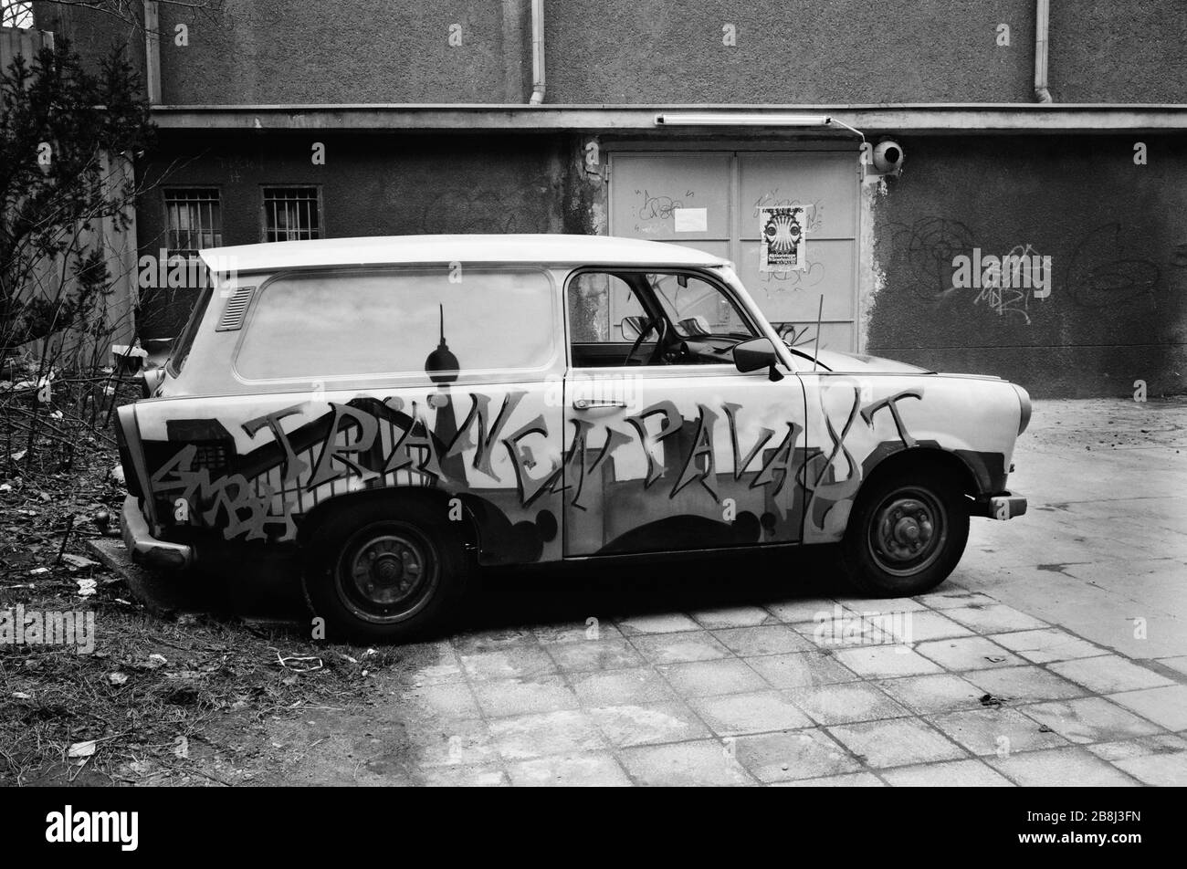 Un'auto Trabant dipinta dalla Germania dell'Est parcheggiata accanto alla stazione di Friedrich Strasse, vicino a dove il muro di Berlino era stato precedentemente eseguito. Il Muro di Berlino era una barriera costruita dalla Repubblica democratica tedesca (RDT, Germania orientale) a partire dal 13 agosto 1961, che ha completamente tagliato Berlino Ovest dalla Germania Est circostante e da Berlino Est. Il Muro è stato aperto il 9. Novembre 1989 consentire la libera circolazione delle persone da est a ovest. Foto Stock