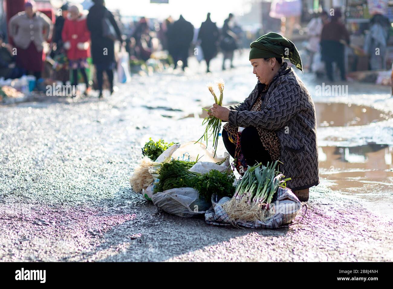 Donna che vende piccole quantità di verdure al mercato di strada, Khiva, Uzbekistan Foto Stock