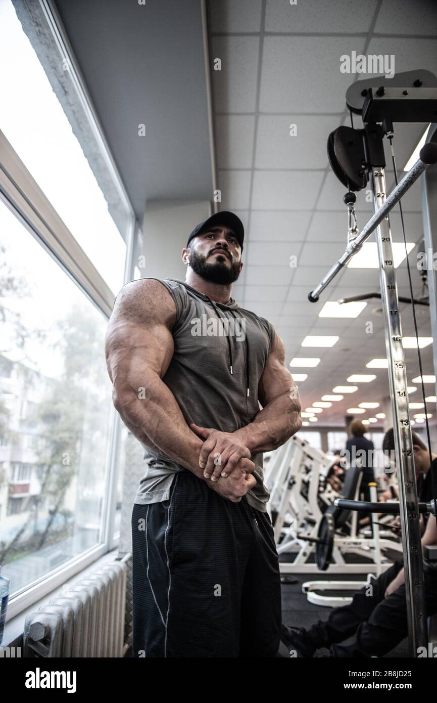 giovane uomo bearded con muscoli forti che mostrano la posa potente in palestra Foto Stock