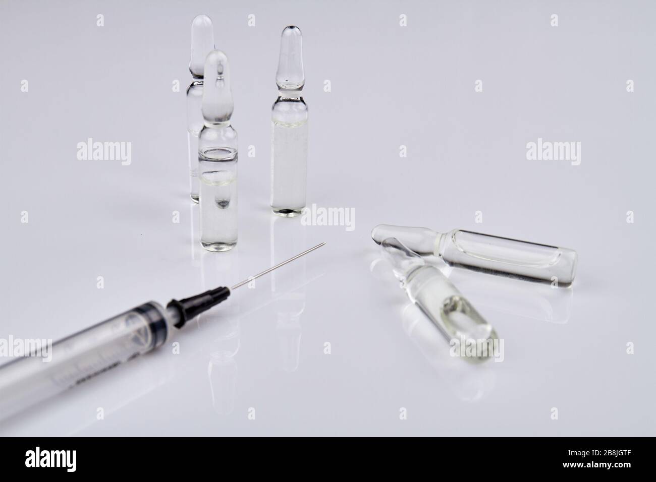 Fiale per uso medico e siringa isolate su bianco. Foto Stock