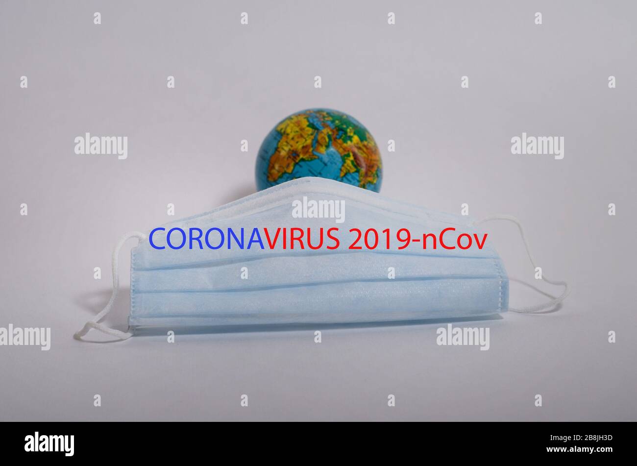 Concetto di Coronovirus. Una maschera medica di fronte al pianeta Terra per combattere il virus con l'iscrizione. Un mondo colpito da epidemie. Foto Stock