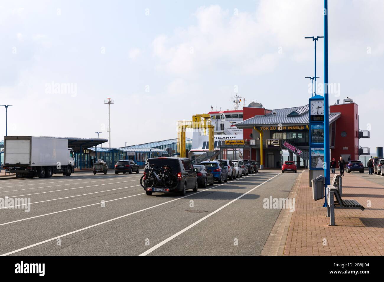 Dagebüll, Germania - 5 marzo 2020: Vista panoramica del terminal dei traghetti a bassa marea, traghetto UTHLANDE ormeggiato, auto in attesa in linea. Foto Stock
