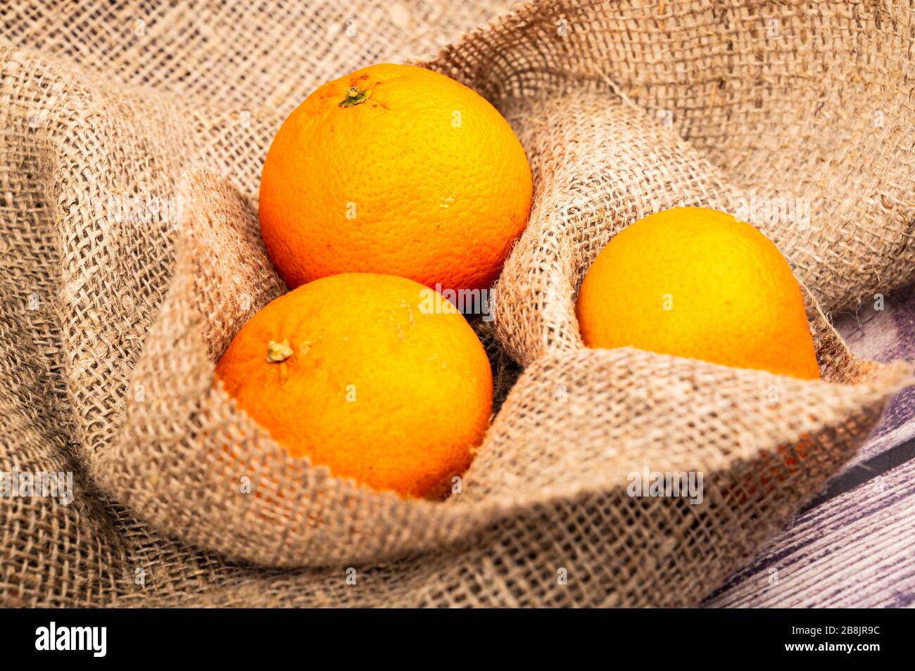 Succosi tangerini maturi su uno sfondo di tessuto omespun ruvido. Primo piano Foto Stock