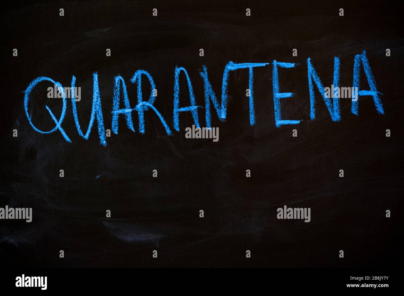 Quarantena di parole in italiano su una lavagna nera. Gesso blu Foto Stock