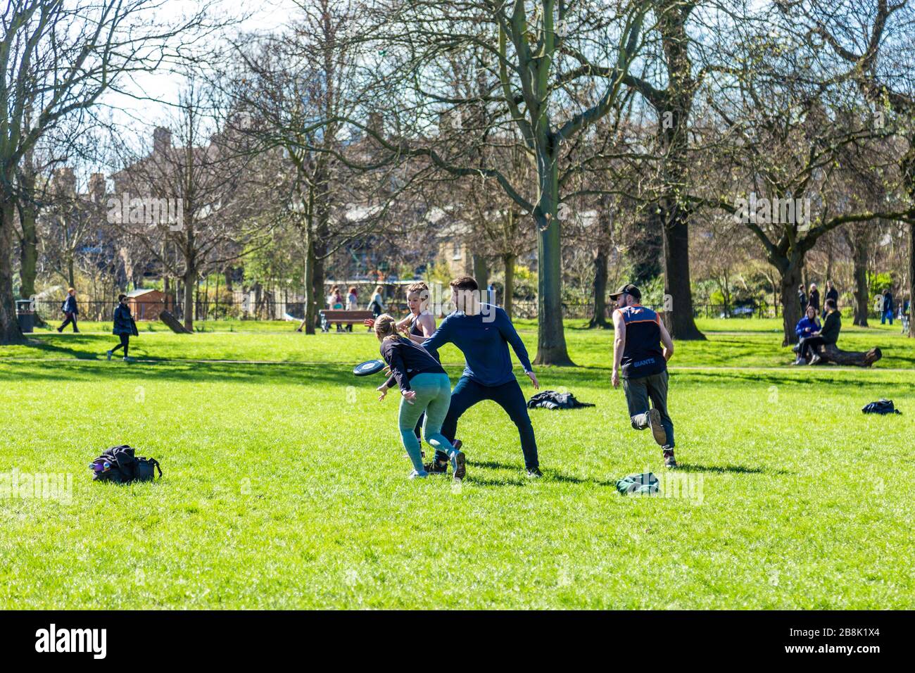 22 marzo 2020 - Londra, Regno Unito - mondiale coronavirus pandemico, grandi gruppi di persone in visita Victoria Park, nonostante il governo che esorta le persone a rimanere a casa e praticare le distanze sociali per prevenire la diffusione del coronavirus Covid-19, persone che giocano a frisbee nel parco Foto Stock