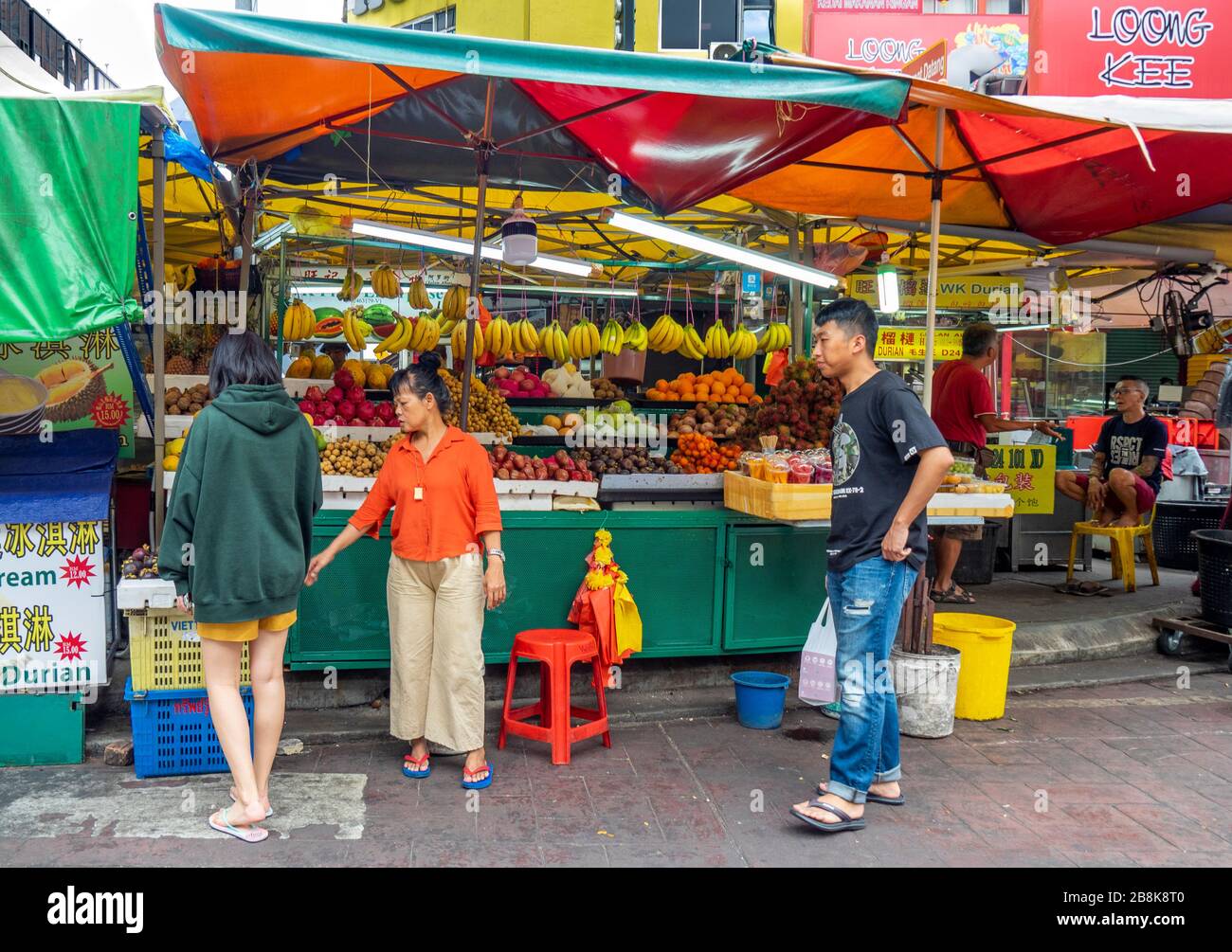 Vender e cliente presso il mercato della frutta fresca presso Jalan Alor Street Bukit Bintang, Kuala Lumpur Malesia. Foto Stock