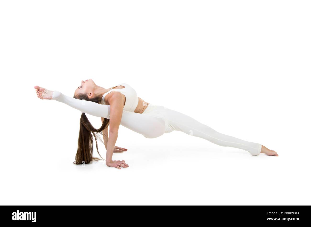 Una giovane donna in tuta bianca esegue elementi acrobatici e yoga. Studio  girato su sfondo bianco. Immagine isolata Foto stock - Alamy