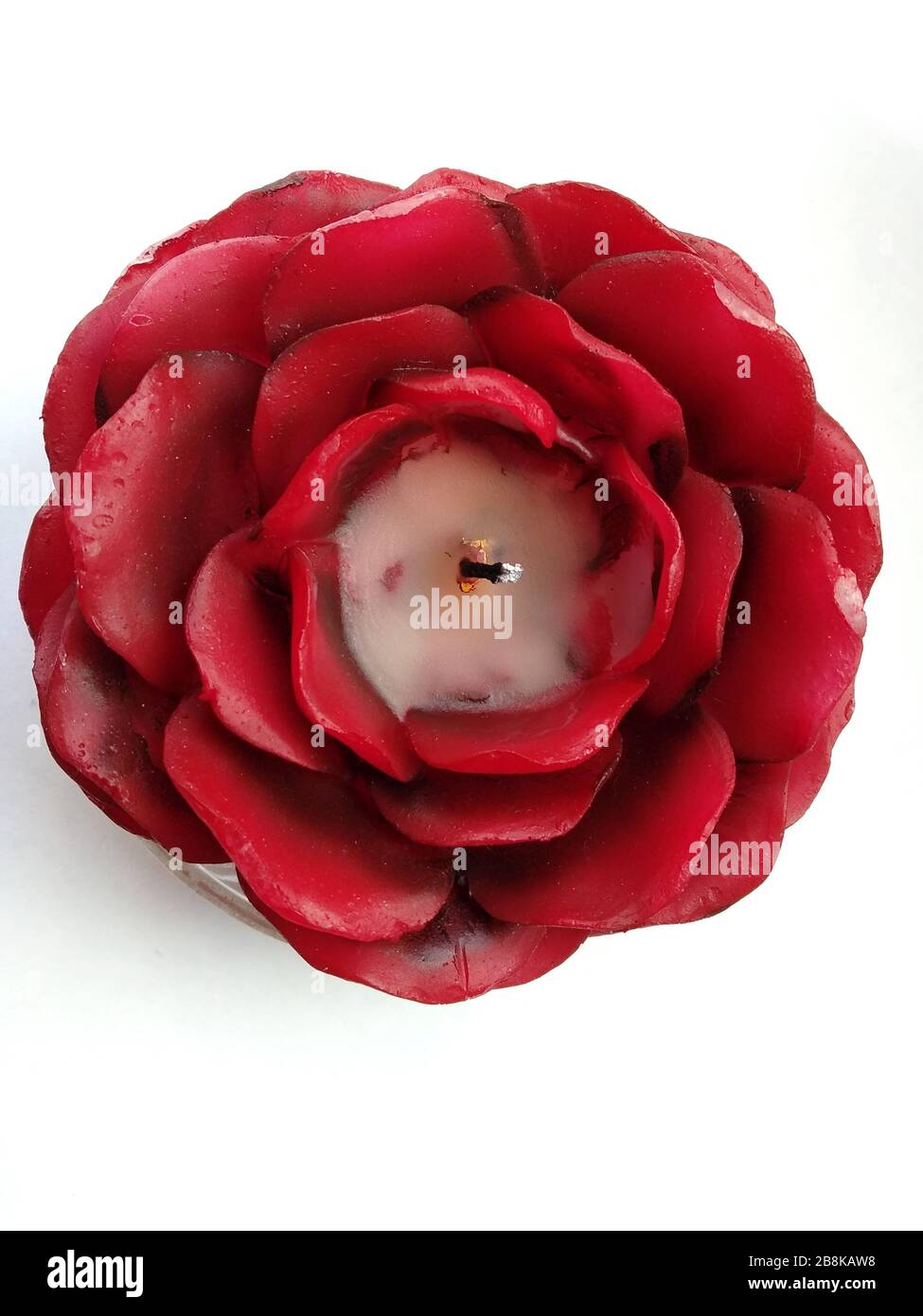 Candela a forma di rosa vista dall'alto. Candela rossa a forma di fiore su  sfondo bianco. Candele profumate per un ambiente romantico Foto stock -  Alamy