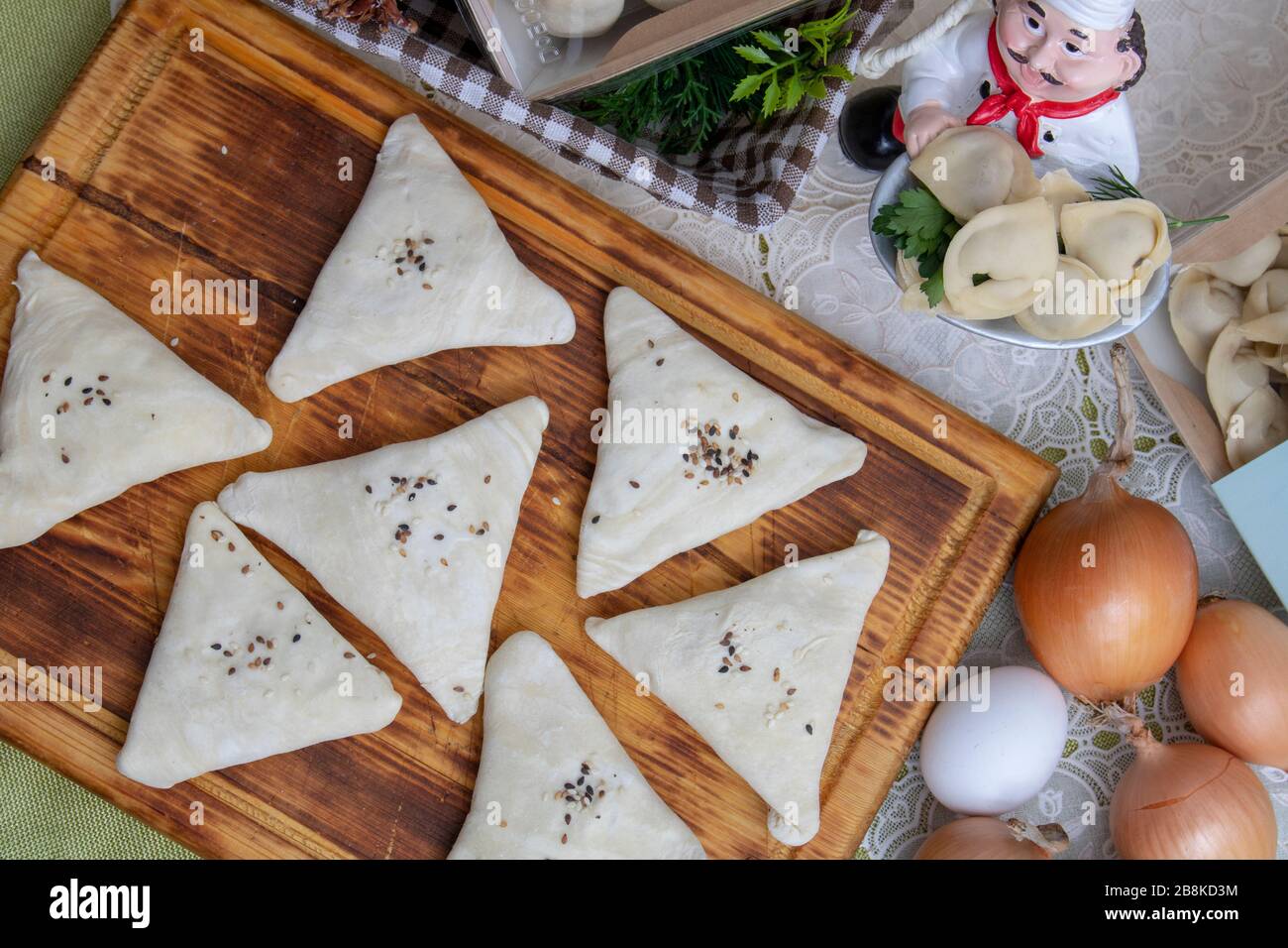 samosa cruda su un piatto con uova e lattuga su un tavolo di legno. primo piano orizzontale. piatto Foto Stock