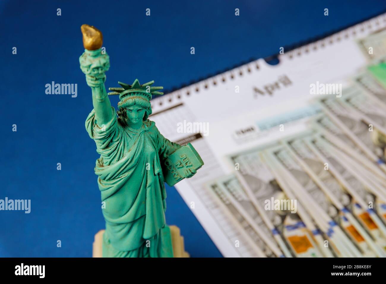 Statua Liberty nel periodo delle imposte negli Stati Uniti con modulo delle imposte USA 1040, denaro e calendario USS dollari, restituzione delle imposte Foto Stock