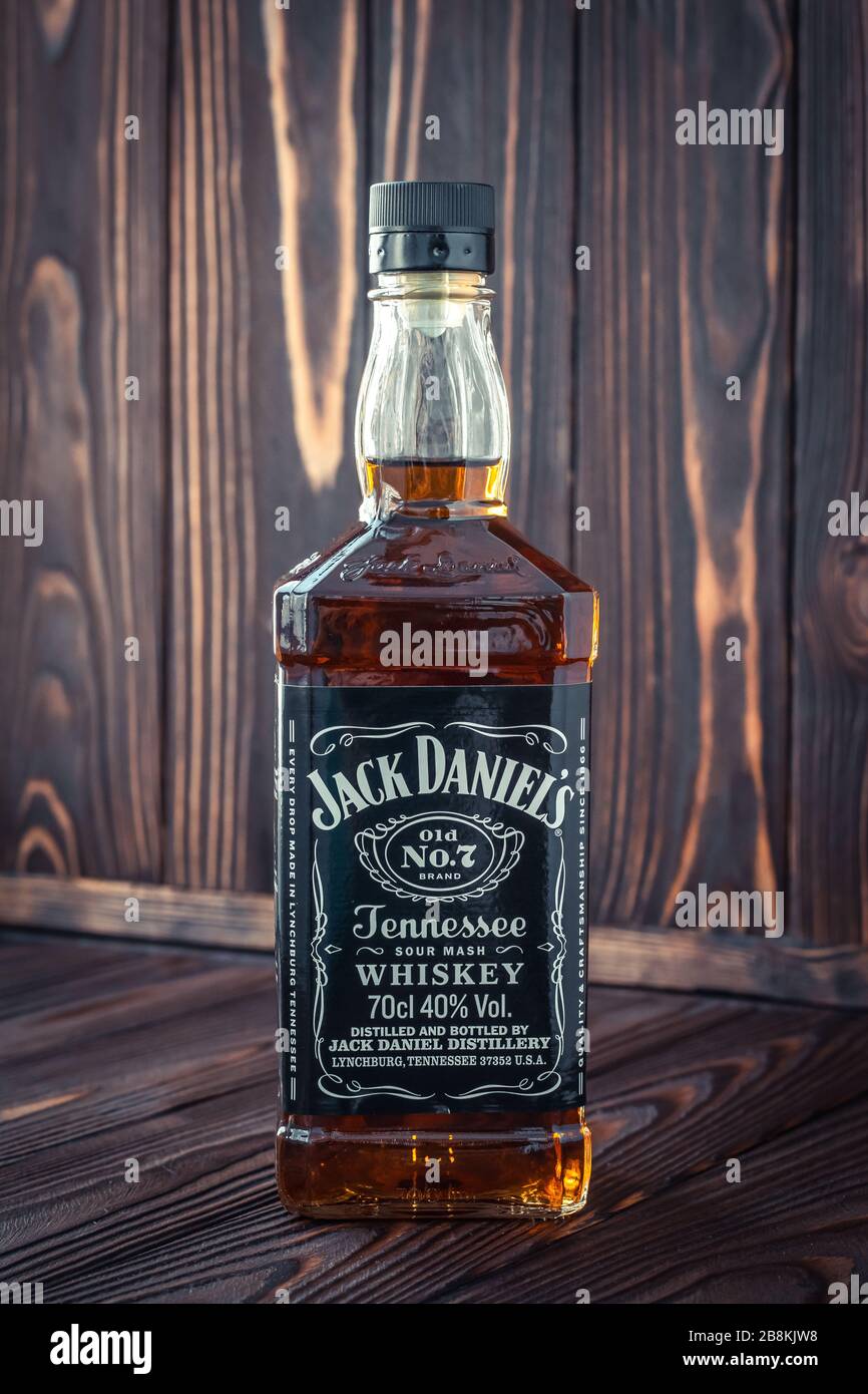 Kharkiv, Ucraina, 22 marzo 2020: Una bottiglia piena di whisky americano Jack Daniel su sfondo di legno scuro. Bevanda forte. editoria illustrativa Foto Stock