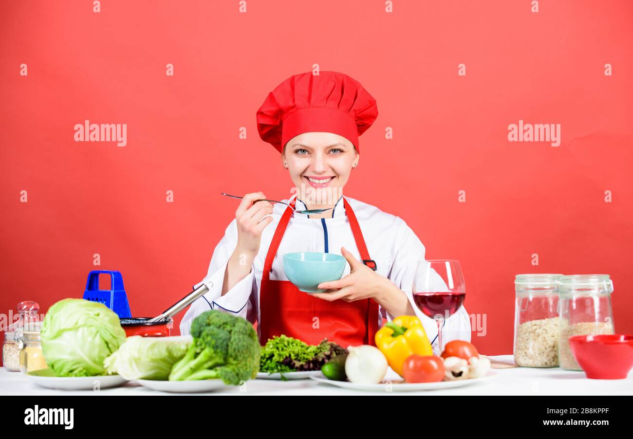 donna in cappello da cuoco. chef professionista su sfondo rosso. donna felice che cucinano cibi sani secondo la ricetta. cibo biologico e vegetariano. Casalinga, menu del ristorante. Dieting. Chi si preoccupa della dieta. Foto Stock