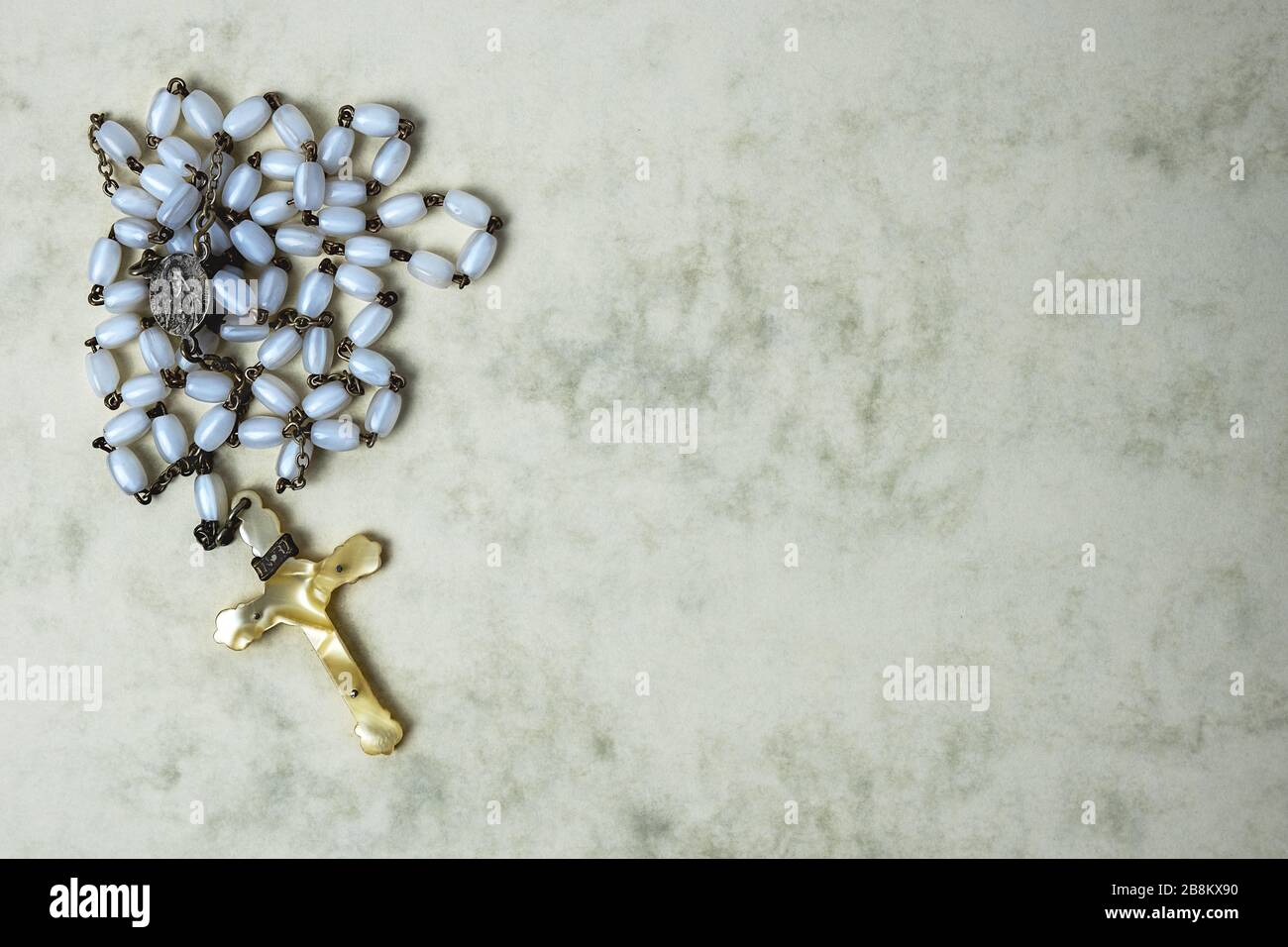 rosario con perline bianche, croce d'avorio e piccola e piccola placca con l'immagine di Gesù Foto Stock