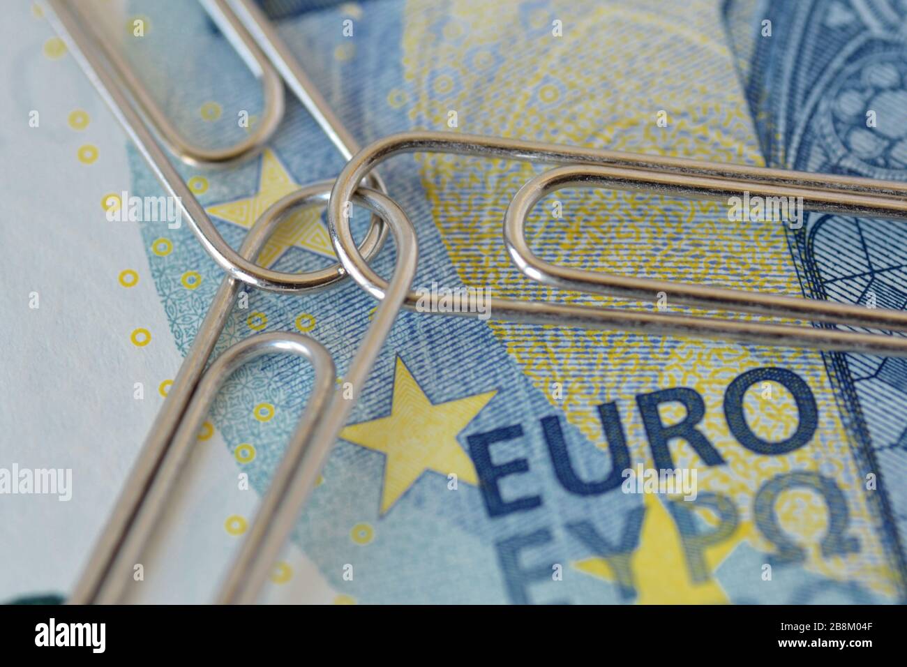 Banconota in euro con tre clip di carta unite - concetto di Unione e lavoro di squadra Foto Stock