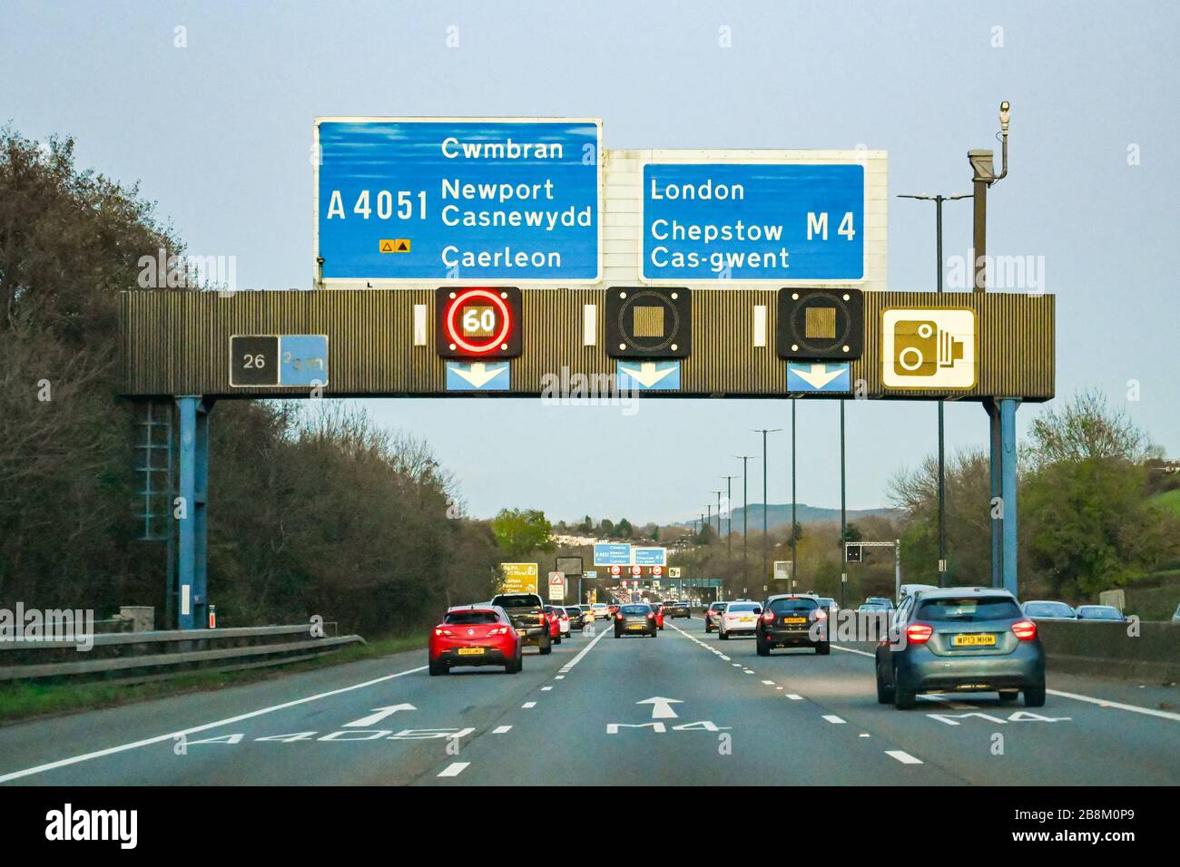 NEWPORT, GALLES - NOVEMBRE 2019: Traffico sull'autostrada M4 a Newport al crepuscolo. Il gantry porta segnali per la velocità variabile Foto Stock