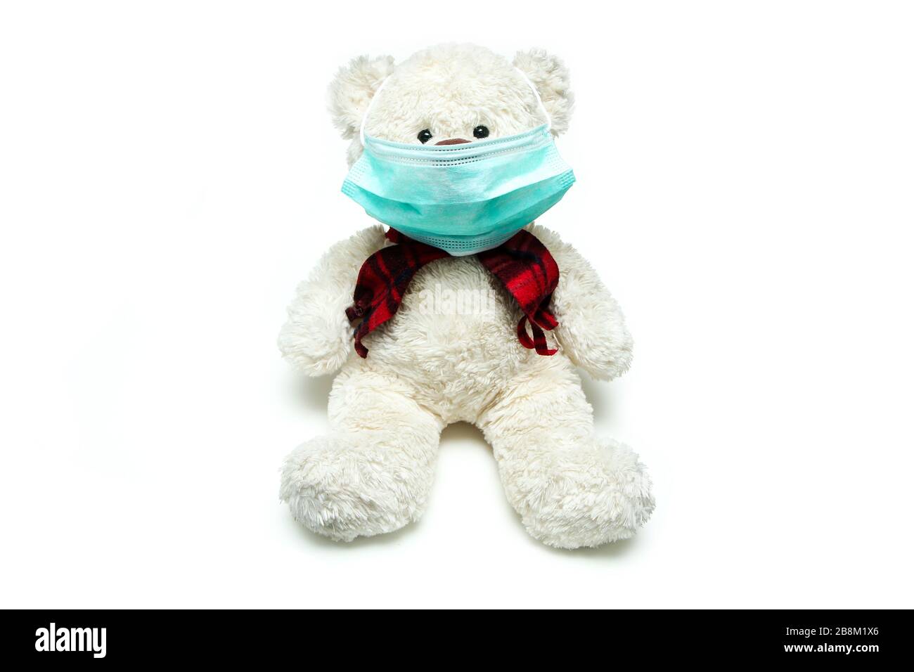 Il peluche teddy con una maschera sul suo viso, come simbolo di protezione contro i virus come il virus corona. Tutti devono indossare una maschera. Foto Stock