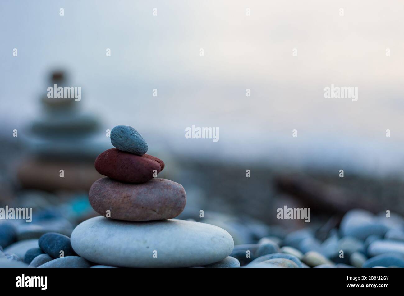 Pila di pietre zen sulla spiaggia ghiaiosa Foto Stock