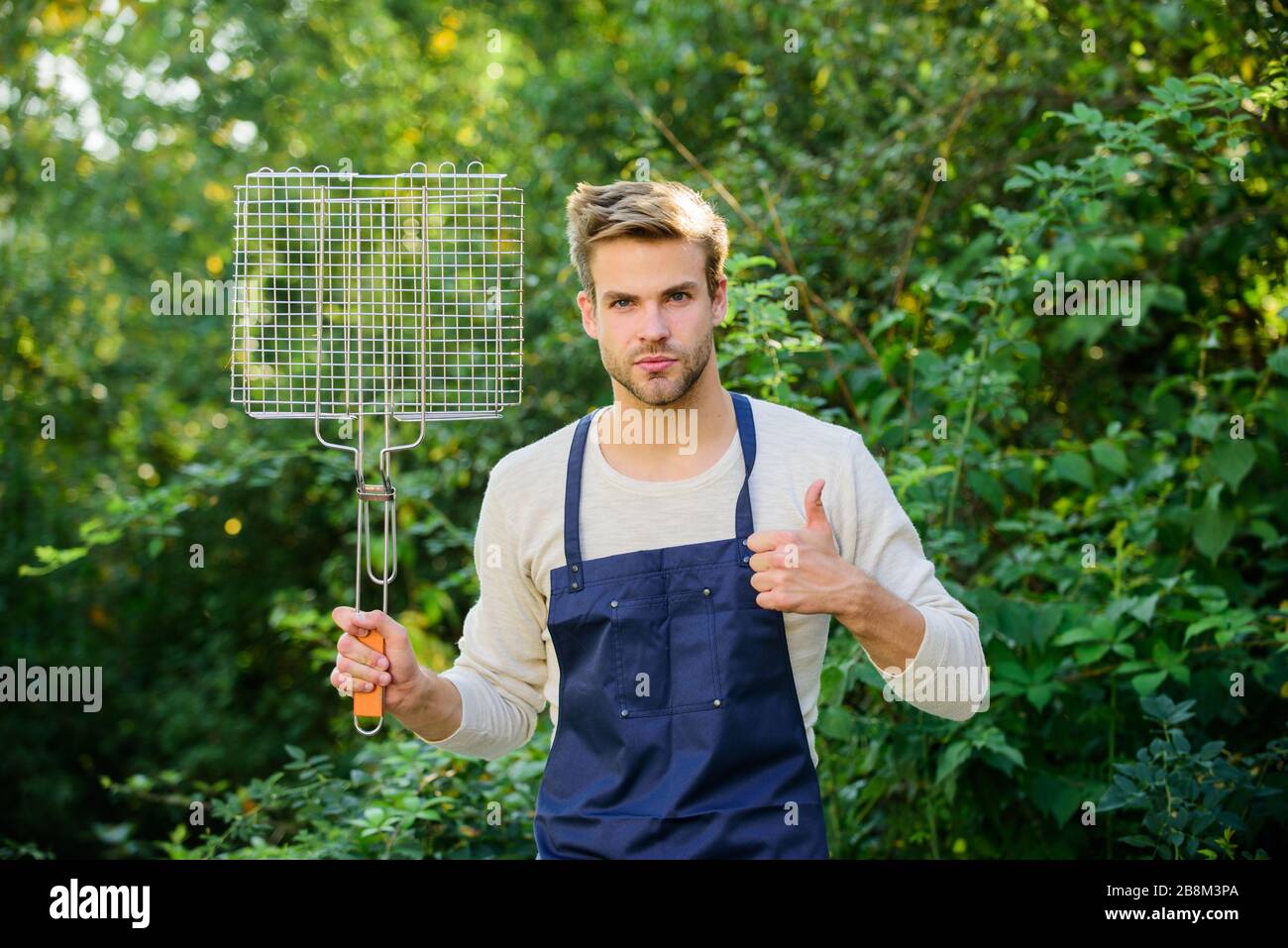 Griglia per grigliare uomo. Grigliare gli alimenti. Festa di barbecue sul cortile. Bel tipo cucina cibo. Concetto di picnic. Pasto sano. Ricetta grill. Metodi diversi grigliare verdure di pollo di manzo e frutti di mare. Foto Stock