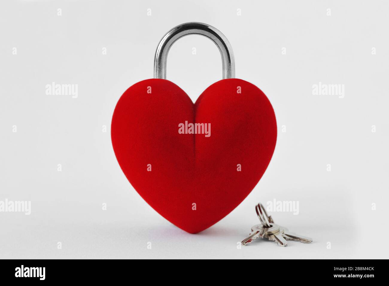 Lucchetto a forma di cuore chiuso con tasti su sfondo bianco - concetto d'amore Foto Stock