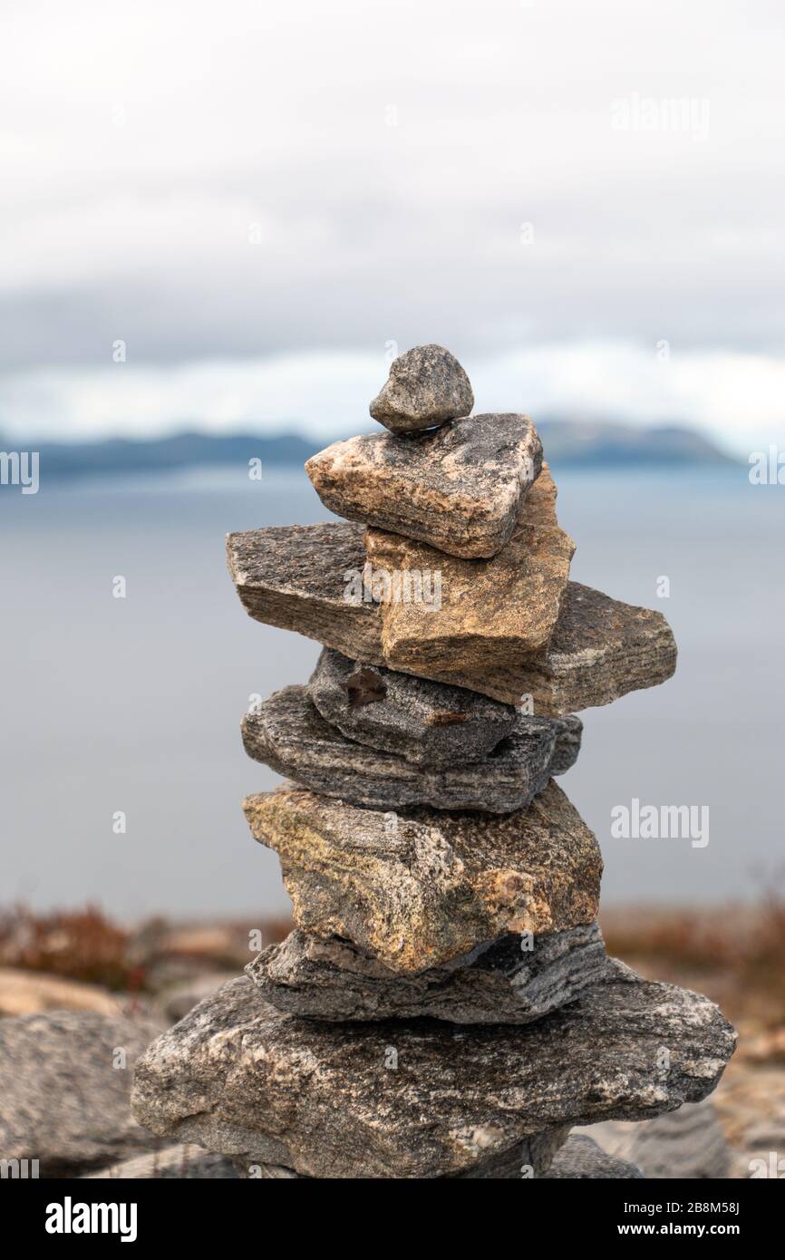 Stack di pietre equilibrate su uno di loro. Nuvole e oceano in background. Foto Stock
