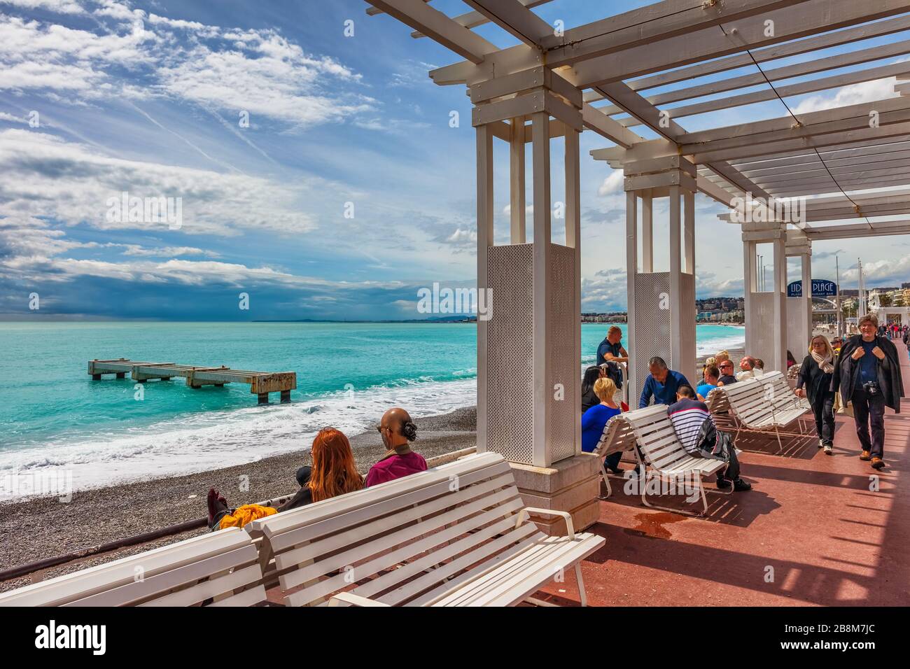 Nizza, Francia - 16 aprile 2018: Persone sia locali che turisti rilassarsi a pergola sulla Promenade des Anglais sulla Costa Azzurra sul Mar Mediterraneo Foto Stock