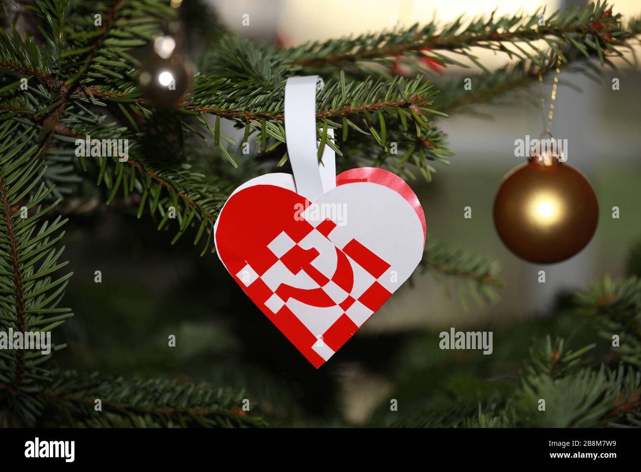 Cuore di Natale con protesta sul capitalismo. Martello e falce. Foto Stock