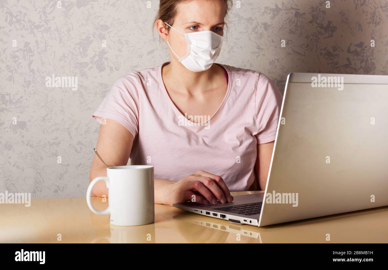 Coronavirus. Giovane donna d'affari che lavora da casa indossando maschera protettiva. Donna d'affari in quarantena per coronavirus indossando maschera protettiva. WOR Foto Stock