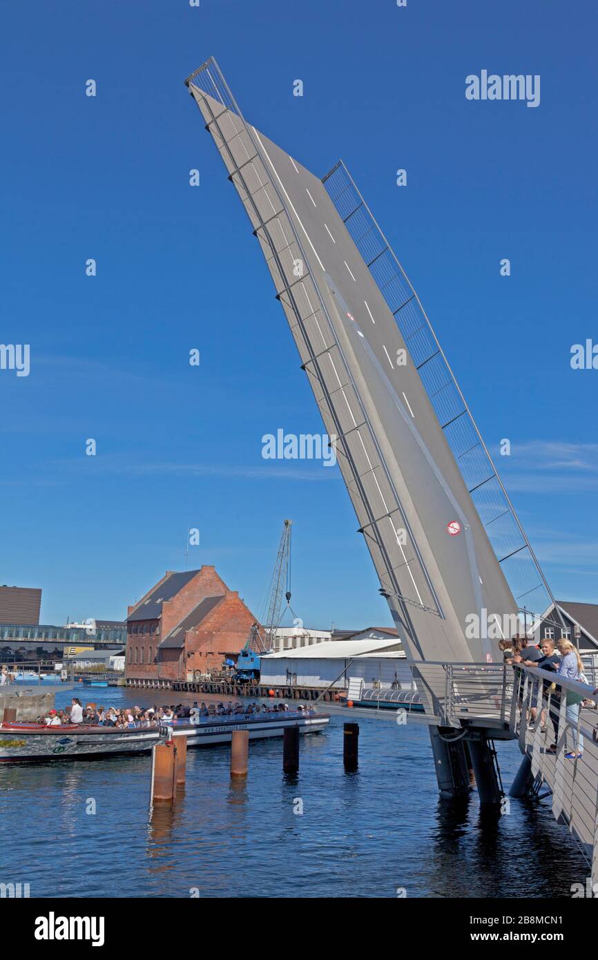 Il ponte Trangrav,Trangravsbroen, una farfalla a 3 vie per il ciclista e il ponte pedonale attraverso Christianshavn canale si apre per una barca. Copenhagen, Danimarca. Foto Stock