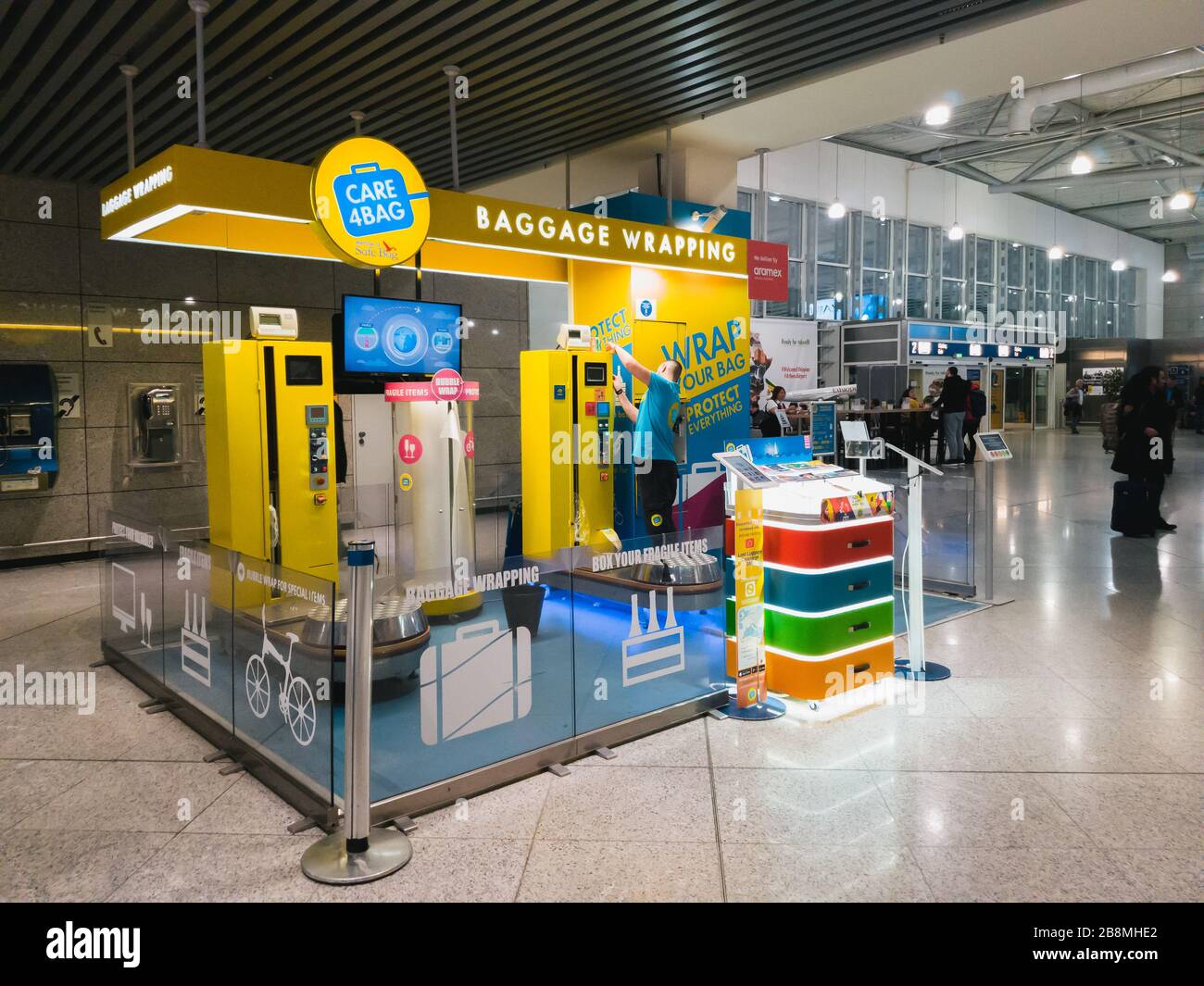 Atene, Grecia - Febbraio, 11 2020: Aeroporto Internazionale Di Atene Eleftherios Venizelos, Grecia. Servizio di imballaggio e tracciamento bagagli Care4Bag, A. Foto Stock