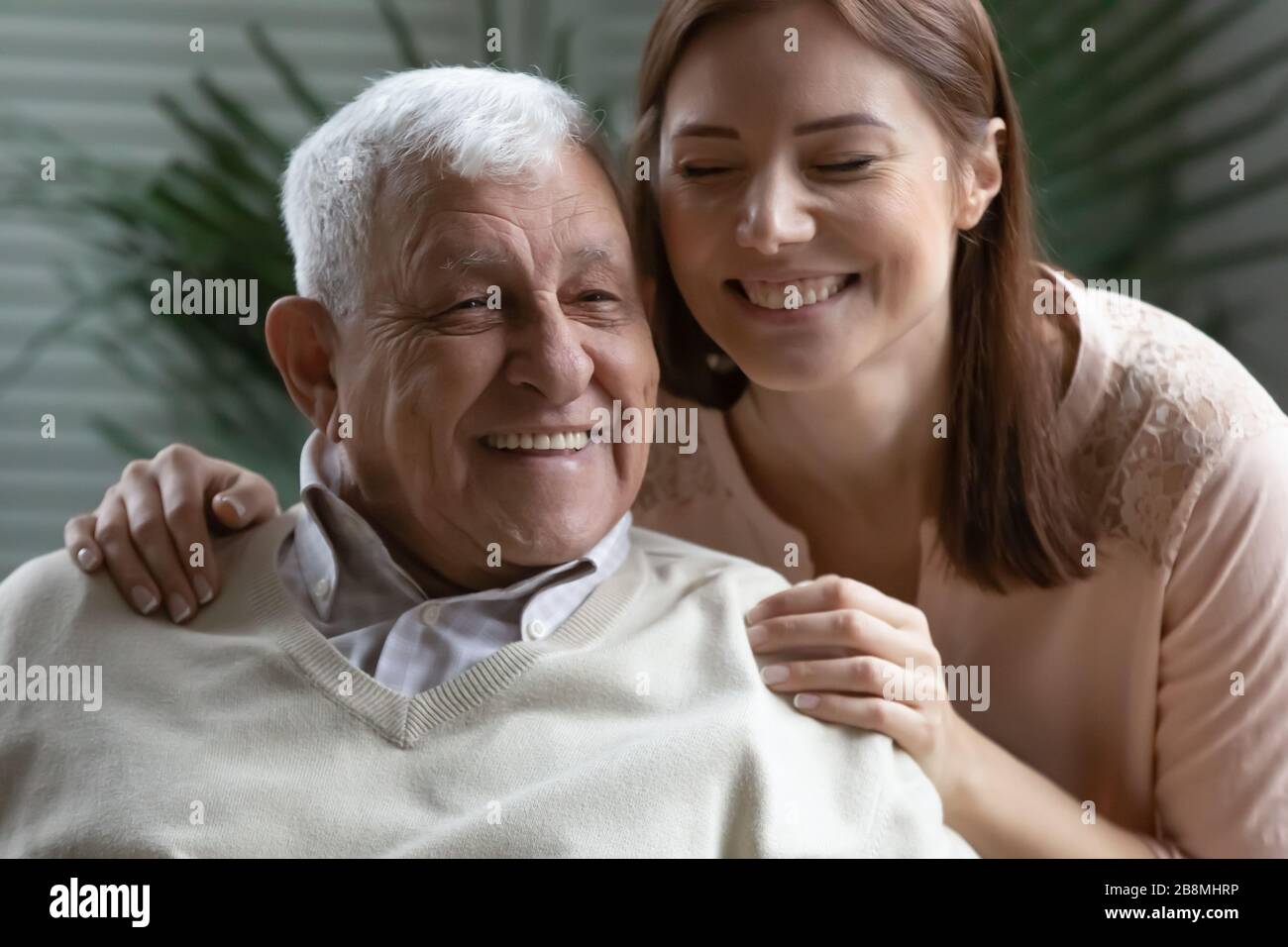 Immagine closeup candid cresciuto figlia abbracci padre anziano Foto Stock
