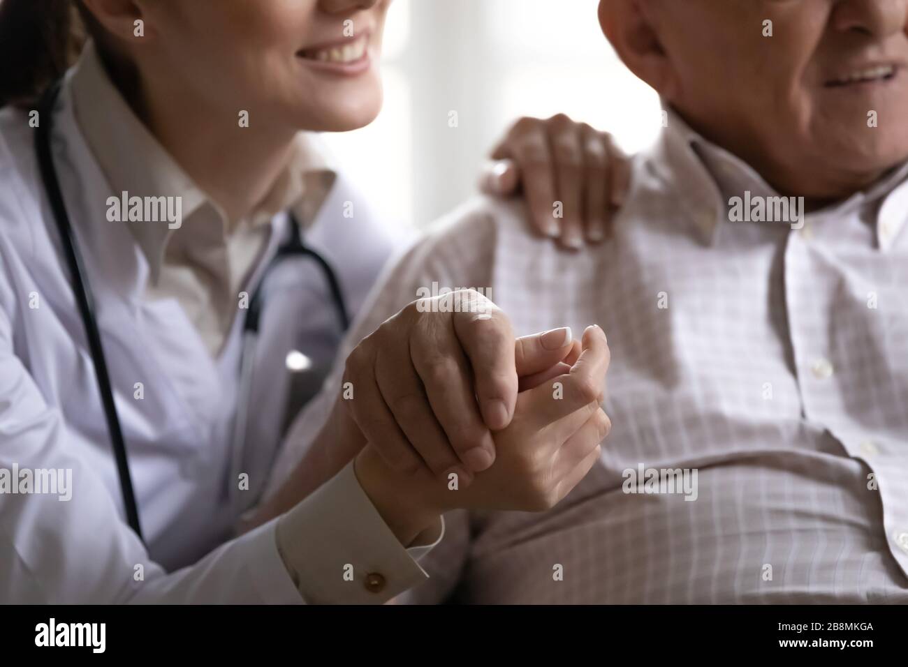 Closeup immagine tagliata infermiere che tiene la mano di vecchio paziente Foto Stock
