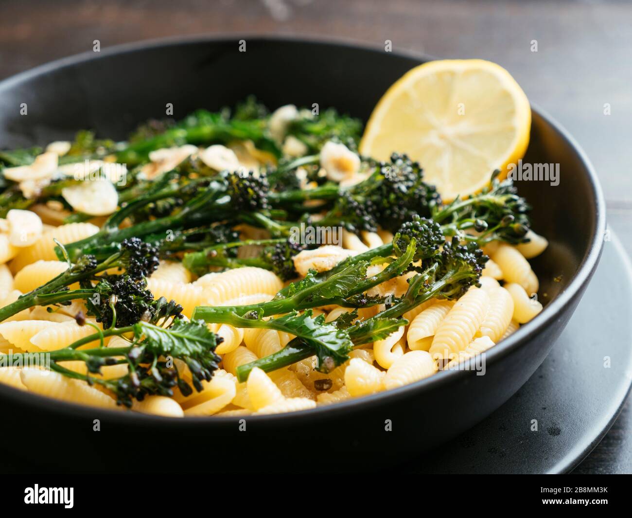 Broccoli germogliati di porpora su pasta con salsa all'aglio di limone Foto Stock
