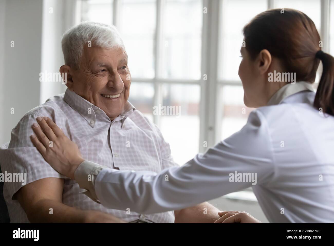 Paziente anziano e comunicazione infermiere attenta all'interno Foto Stock