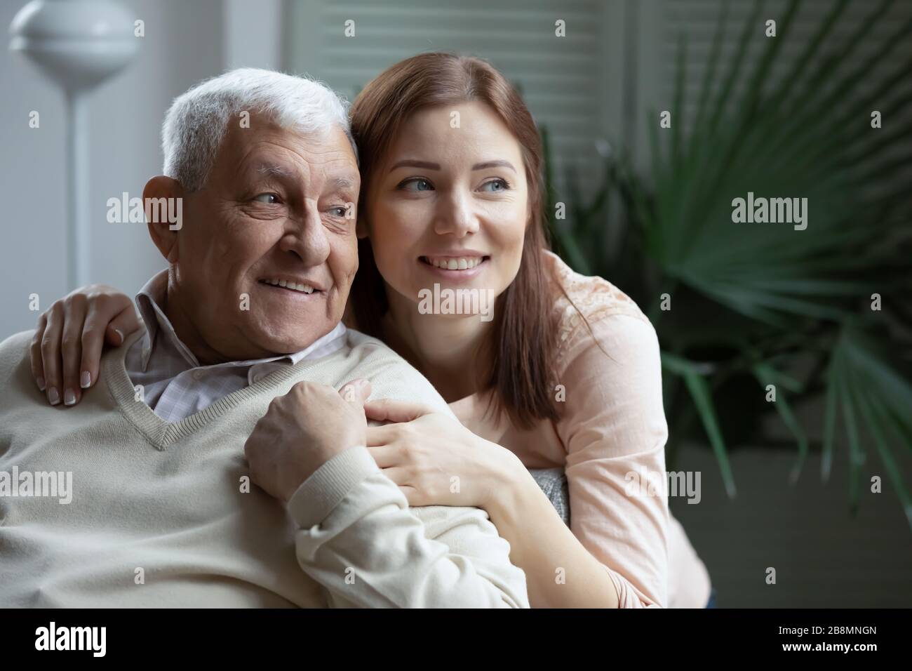 Cresciuto amorevole nipote abbracciare anziani 75s nonno Foto Stock