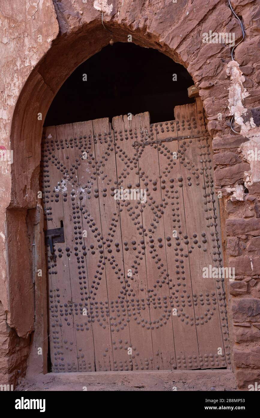 Porta invecchiata, a turni, chiodata utilizzata per chiudere una porta tradizionale araba ad arco, Marocco, Nord Africa. Foto Stock