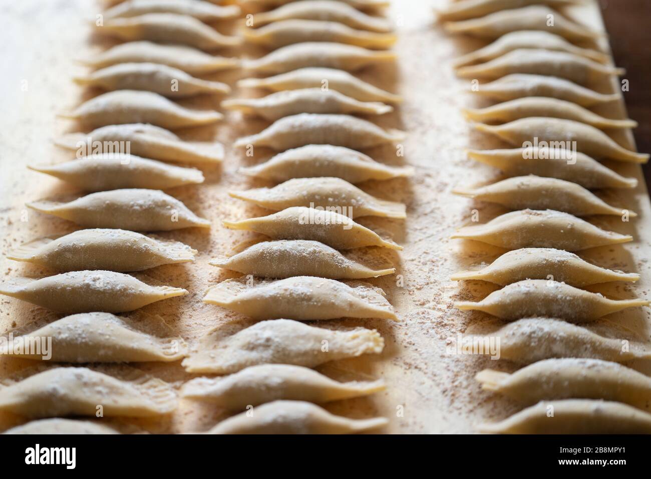 Pasta Ravioli fatta a mano su un tavolo di legno Foto Stock