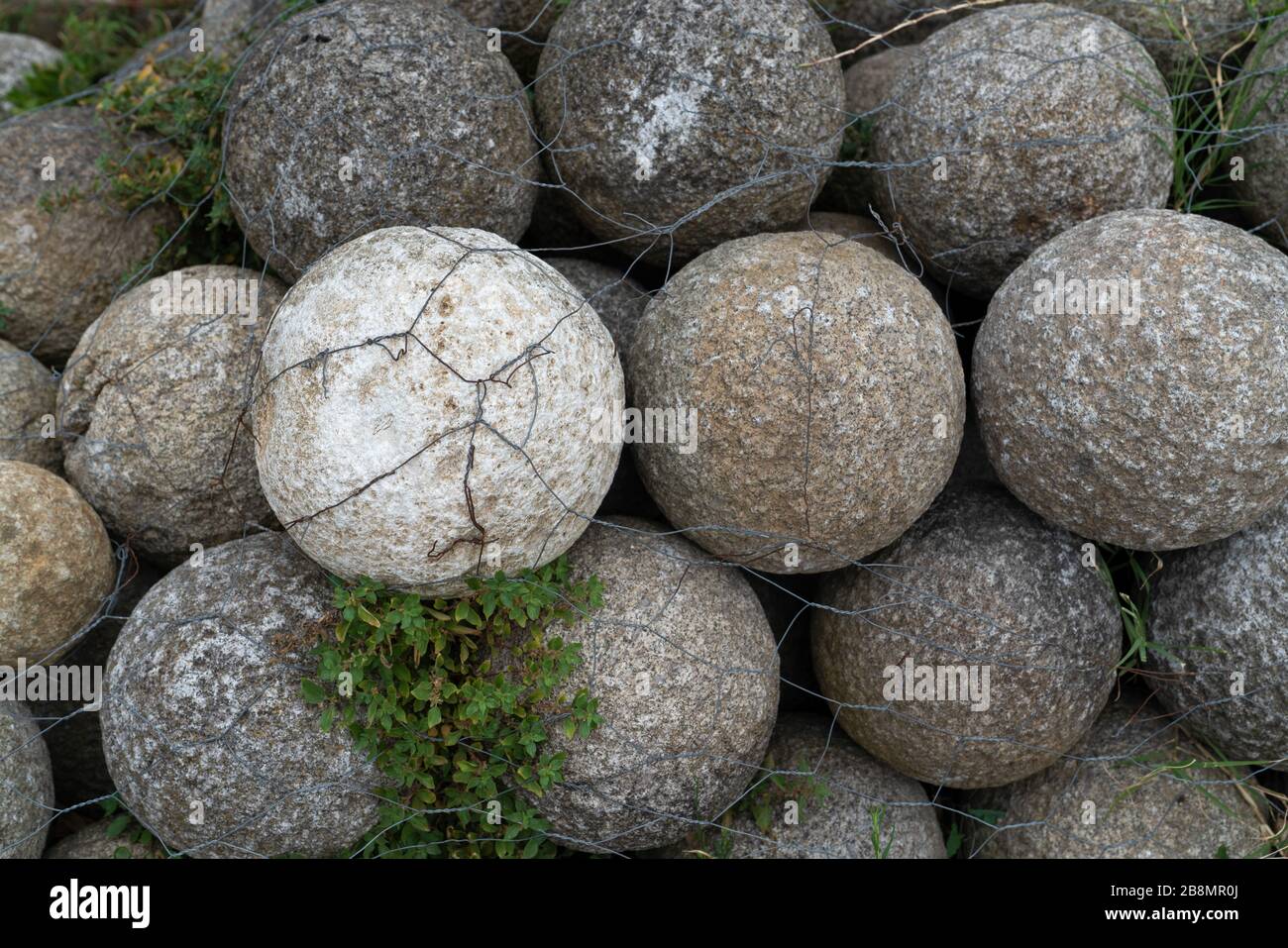 Nuclei di pietra rotondi per un'antica catapulta impilati in una piramide Foto Stock