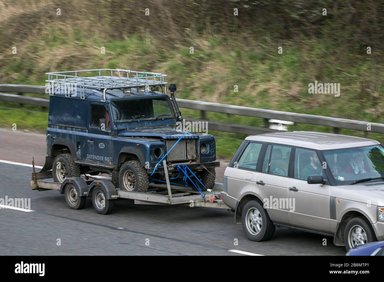 Vecchia reliquia Land Rover Defender su rimorchio che guida sull'autostrada M6 vicino Preston in Lancashire, Regno Unito Foto Stock