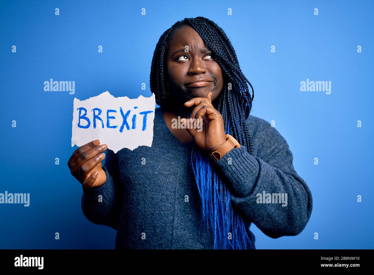 Giovane african american più donna con trecce che tiene carta con il messaggio brexit faccia seria pensare alla domanda, idea molto confusa Foto Stock