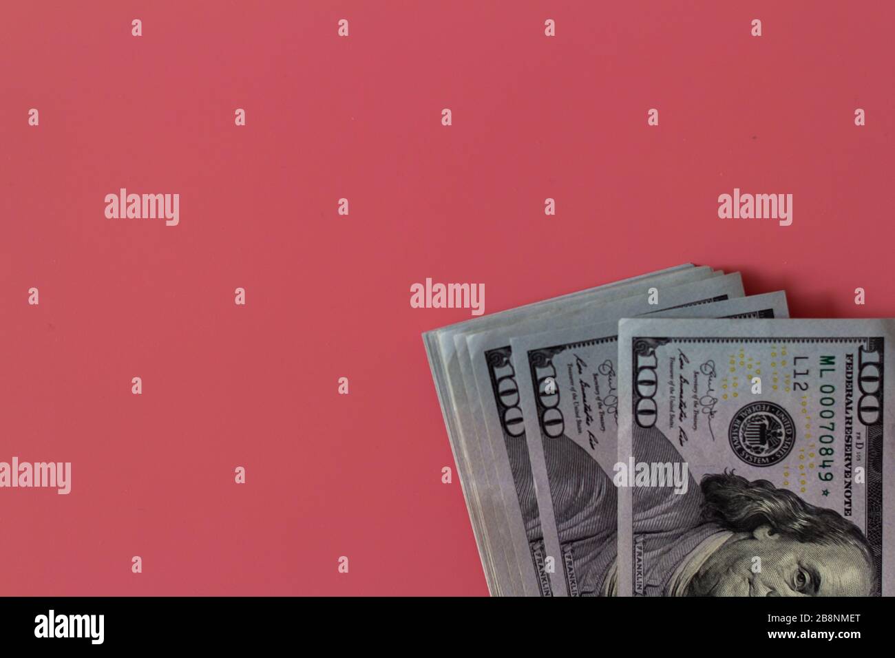 Piano primo piano di dollari su sfondo rosa. Utile di investimento. Concetto di successo. Concetto di investimento finanziario. Simbolo del dollaro. Cento dollari di fattura. Foto Stock