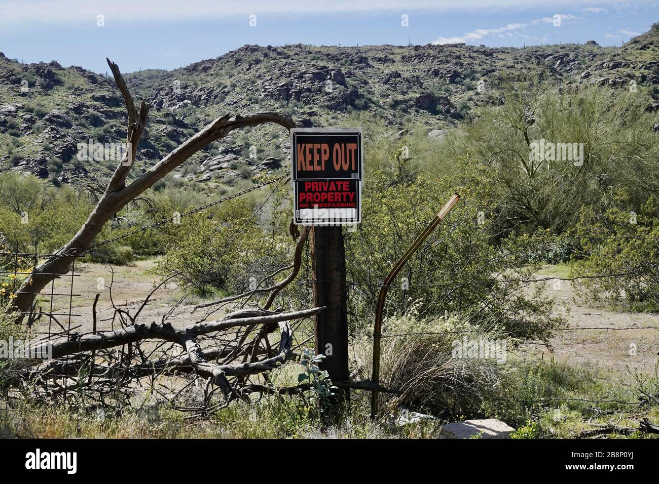 Un cartello di proprietà privata di tenere fuori su una recinzione al di fuori di un sacco di terra nel deserto dell'Arizona. Foto Stock