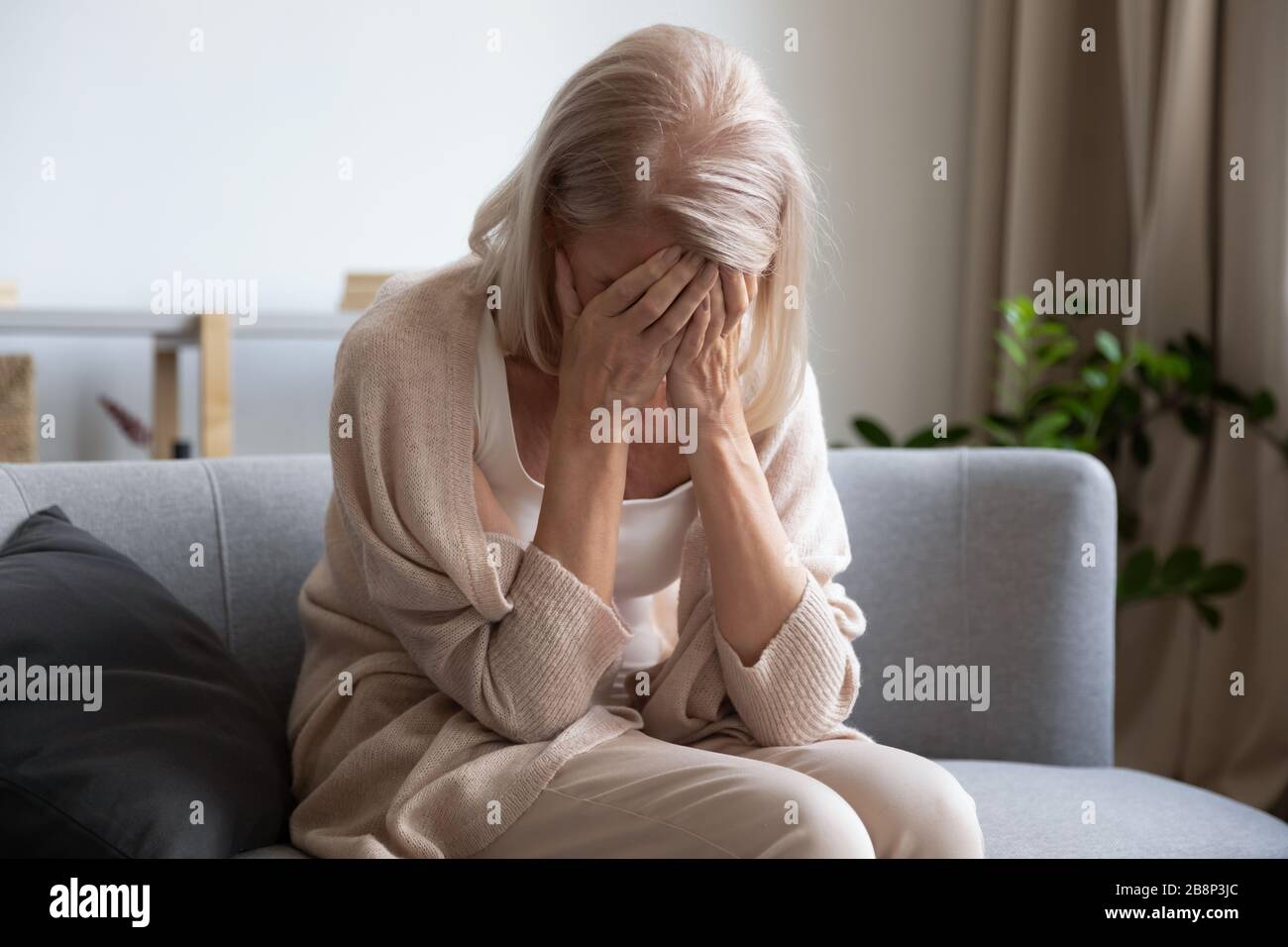 Donna anziana stressata che soffre di solitudine a casa. Foto Stock