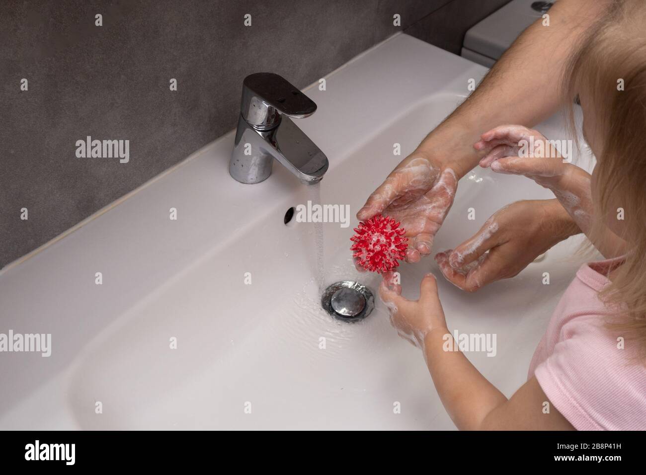 Padre e bambino lavano le mani per proteggere dal virus della corona Foto Stock
