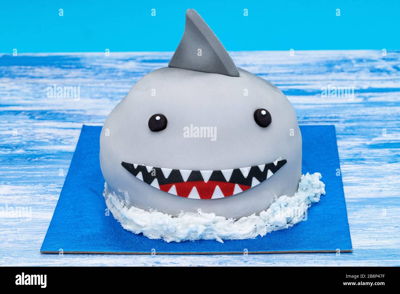 Una torta di squalo per bambini - sfondo blu Foto Stock